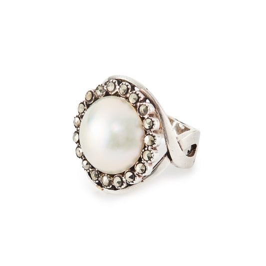 Glamorous vintage sterling silver ring set with a mabé pearl surrounded by nineteen marcasites.