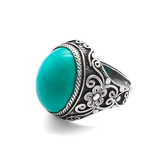 Silver ring set with a beautiful cabochon turquoise stone and ornate filigree embellishment. 