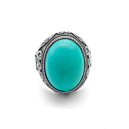 Silver ring set with a beautiful cabochon turquoise stone and ornate filigree embellishment. 