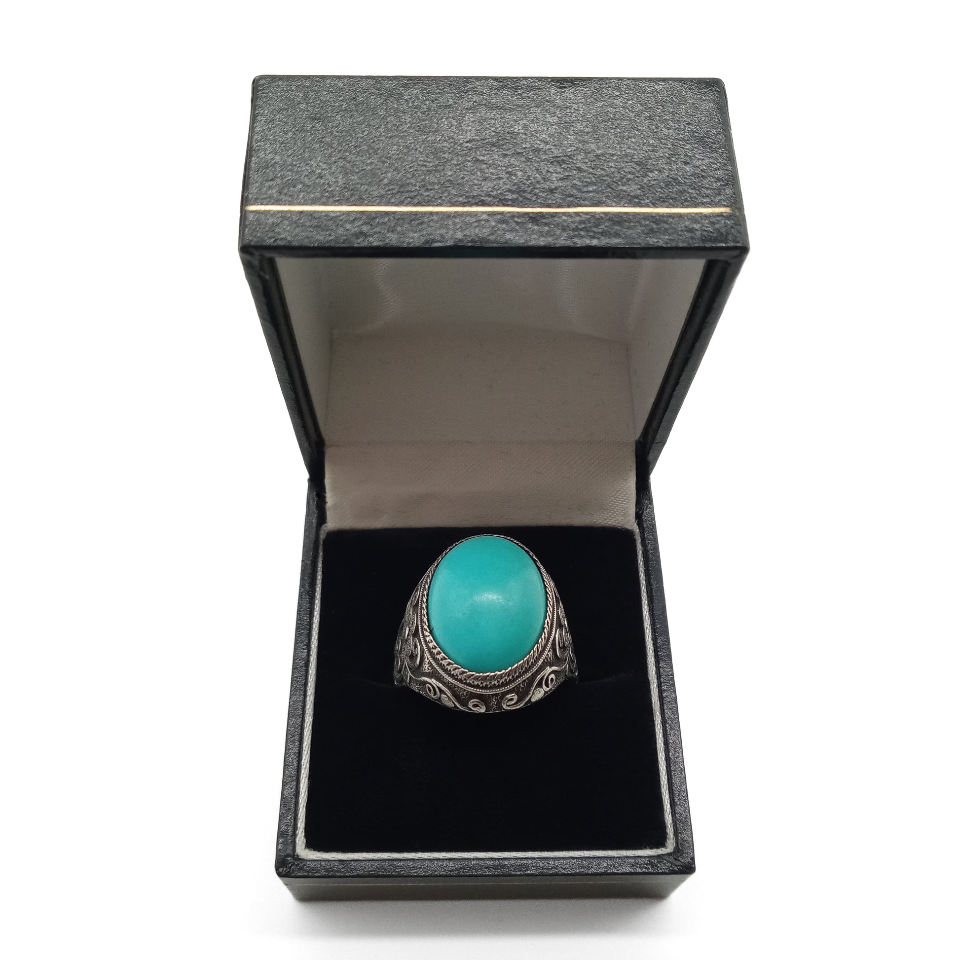 Silver ring set with a beautiful cabochon turquoise stone and ornate filigree embellishment. 