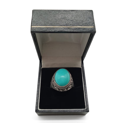 Silver ring set with a beautiful cabochon turquoise stone and ornate filigree embellishment. 