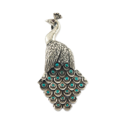 Magnificent Mexican oxidised high grade silver peacock pendant/brooch with twenty-three cabochon turquoise stones set in its articulated tail feathers, with a garnet eye. 