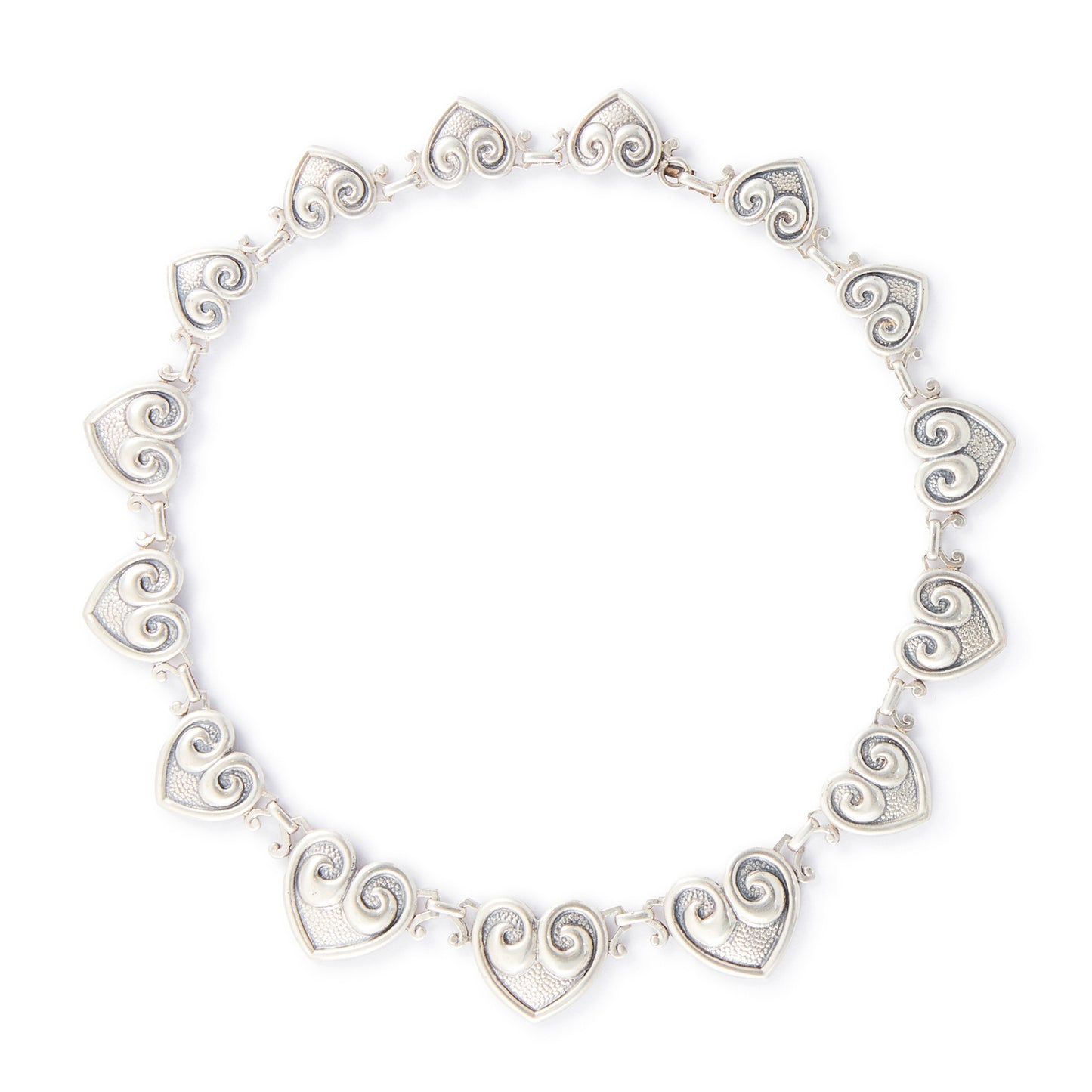 Classic sterling silver Candida choker consisting of fourteen linked repoussé hearts.

Hallmarked: Candida Sterling Silver
