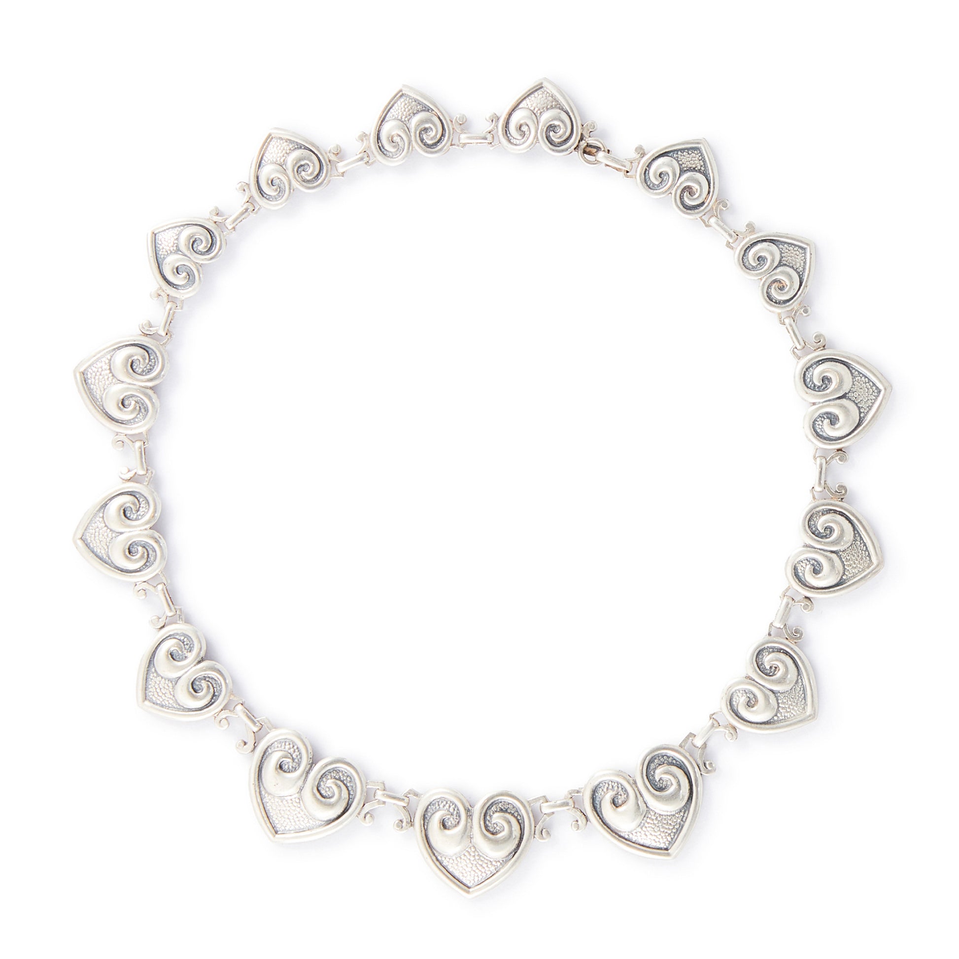 Classic sterling silver Candida choker consisting of fourteen linked repoussé hearts.

Hallmarked: Candida Sterling Silver