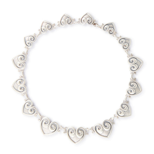 Classic sterling silver Candida choker consisting of fourteen linked repoussé hearts.

Hallmarked: Candida Sterling Silver