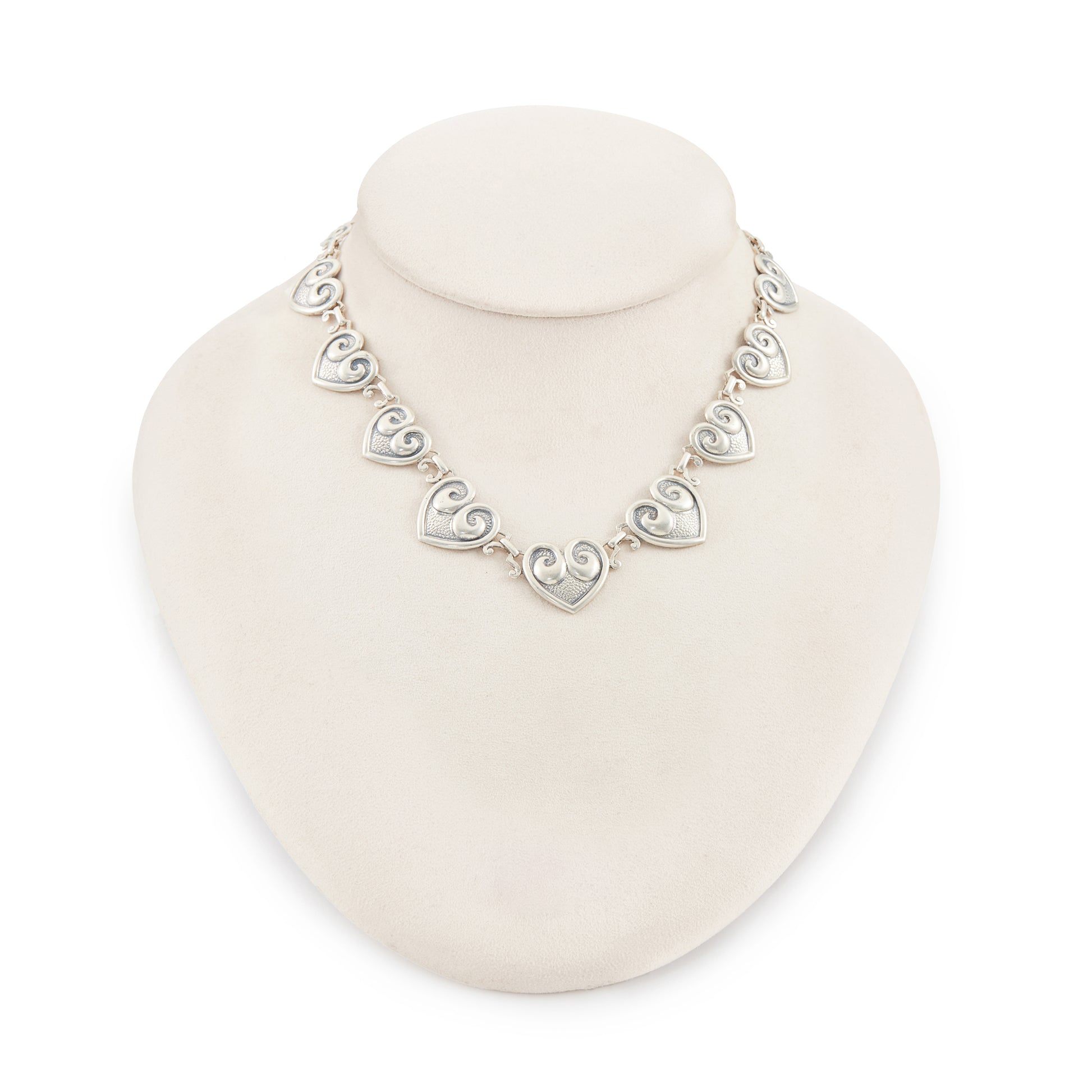 Classic sterling silver Candida choker consisting of fourteen linked repoussé hearts.

Hallmarked: Candida Sterling Silver