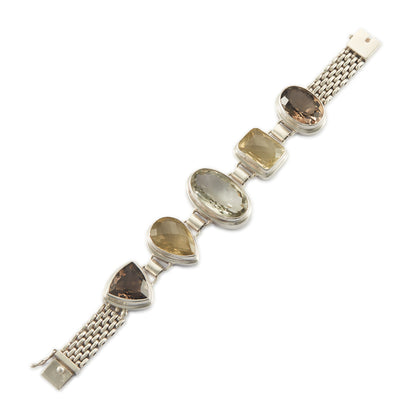 Stunning chunky sterling silver bracelet set with large, beautifully faceted citrine, smoky quartz and a green amethyst in the centre. The bracelet has a safety clasp.