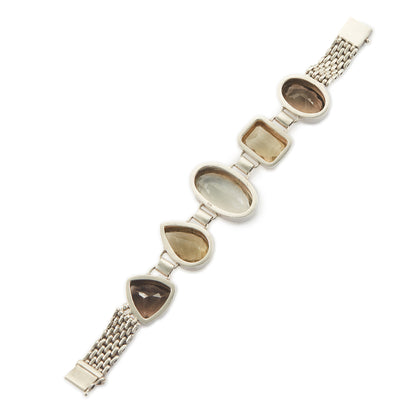 Stunning chunky sterling silver bracelet set with large, beautifully faceted citrine, smoky quartz and a green amethyst in the centre. The bracelet has a safety clasp.
