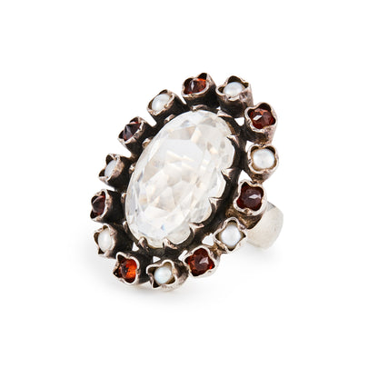 Glamorous sterling silver ring, with a faceted oval rock crystal stone surrounded by seven garnets and seven pearls in an oxidised silver setting.