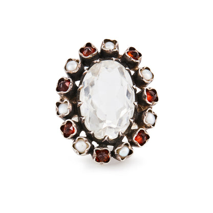 Glamorous sterling silver ring, with a faceted oval rock crystal stone surrounded by seven garnets and seven pearls in an oxidised silver setting.