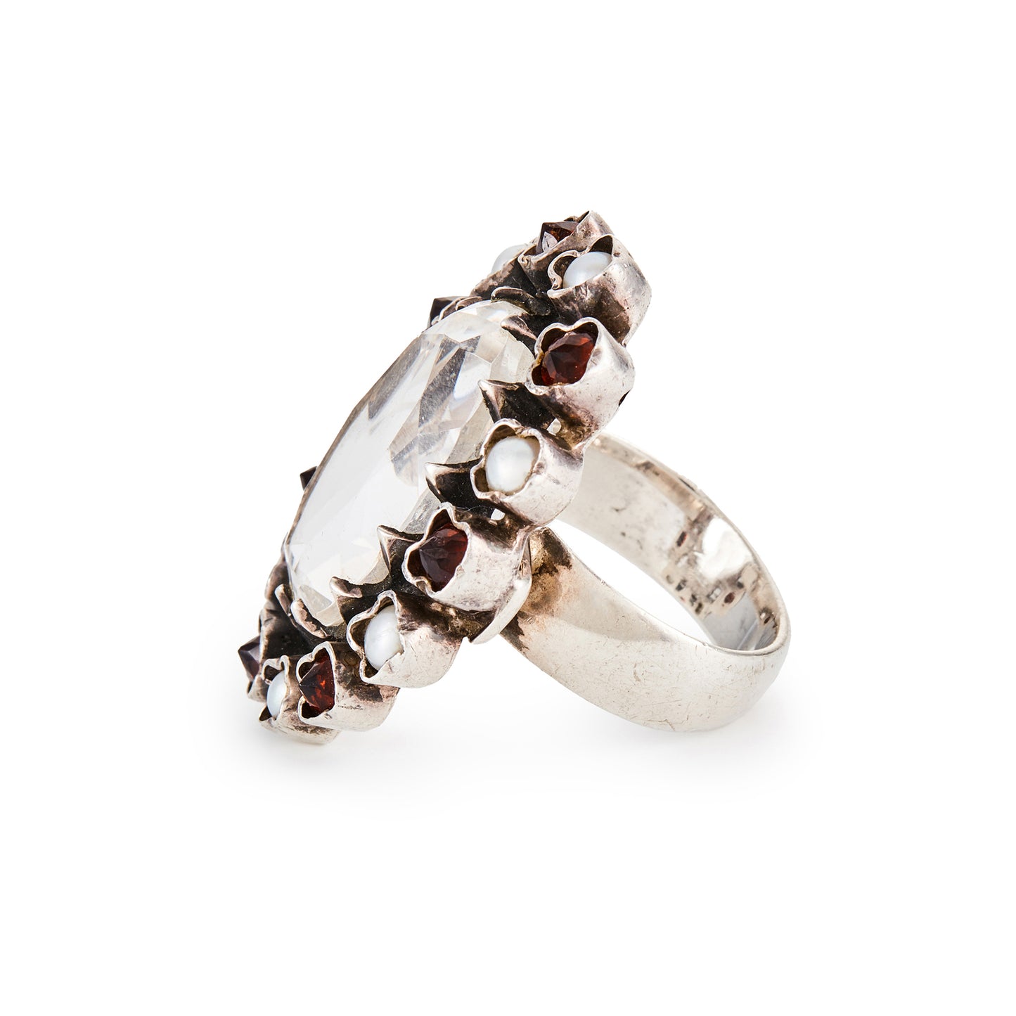 Glamorous sterling silver ring, with a faceted oval rock crystal stone surrounded by seven garnets and seven pearls in an oxidised silver setting.