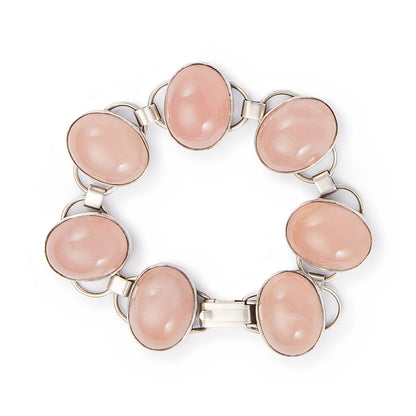 Lovely sterling silver articulated mid-century bracelet set with seven rose quartz cabochon stones. There is oxidation on the back of the bracelet.