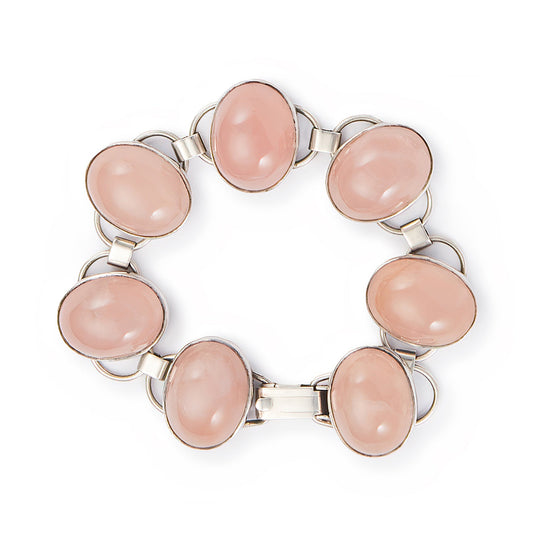 Lovely sterling silver articulated mid-century bracelet set with seven rose quartz cabochon stones. There is oxidation on the back of the bracelet.