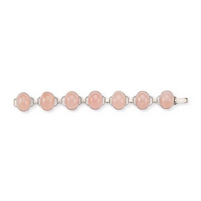 Lovely sterling silver articulated mid-century bracelet set with seven rose quartz cabochon stones. There is oxidation on the back of the bracelet.