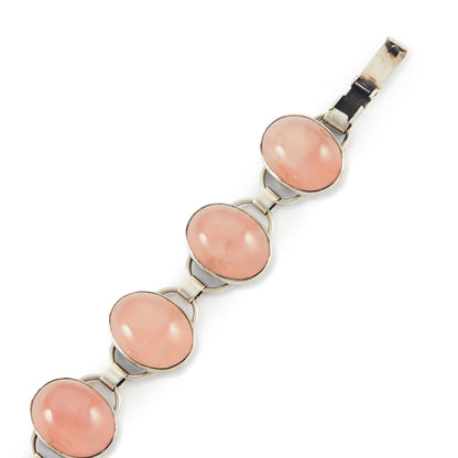 Lovely sterling silver articulated mid-century bracelet set with seven rose quartz cabochon stones. There is oxidation on the back of the bracelet.