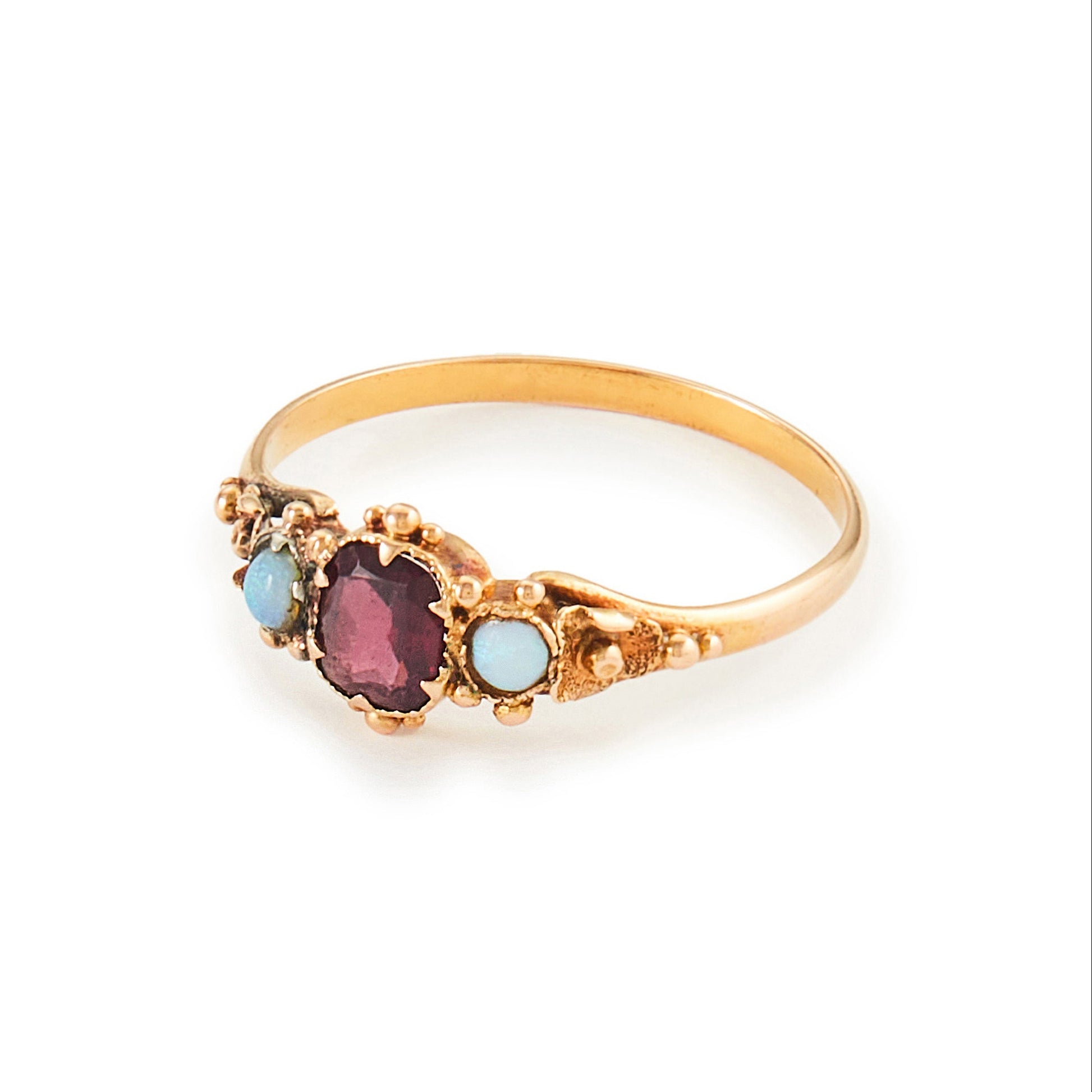 Delicate Victorian 15ct gold three stone ring set with two small opal cabochons and a faceted rhodolite garnet.