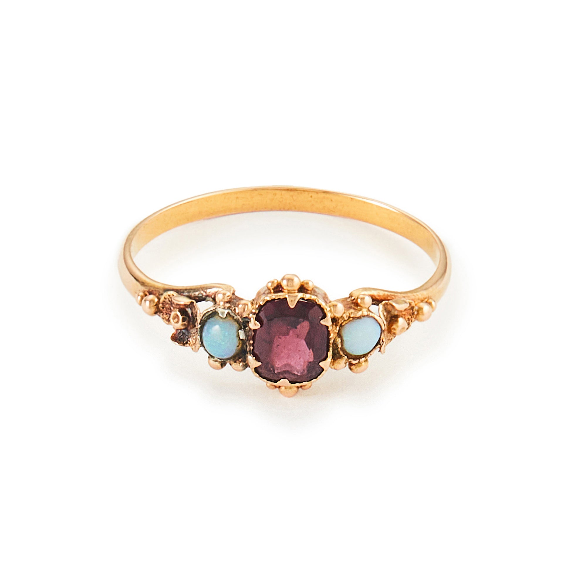 Delicate Victorian 15ct gold three stone ring set with two small opal cabochons and a faceted rhodolite garnet.