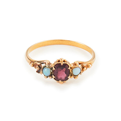 Delicate Victorian 15ct gold three stone ring set with two small opal cabochons and a faceted rhodolite garnet.