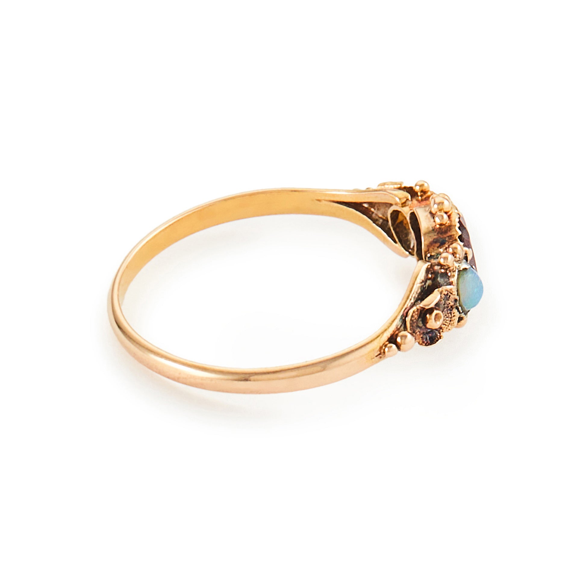 Delicate Victorian 15ct gold three stone ring set with two small opal cabochons and a faceted rhodolite garnet.