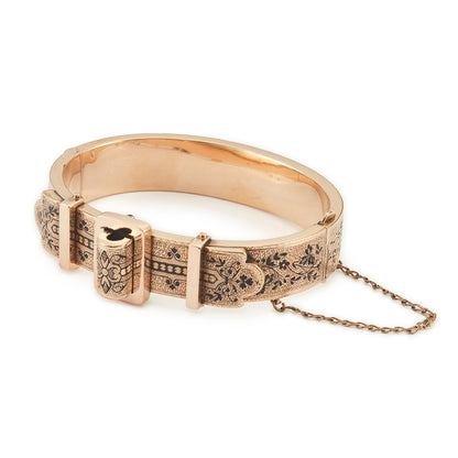 Exquisite Victorian 9ct rose gold hollow buckle bangle, embellished with beautiful intricate black enamel floral design. Opens with hinge mechanism. Safety chain attached.