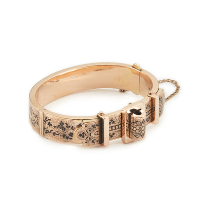 Exquisite Victorian 9ct rose gold hollow buckle bangle, embellished with beautiful intricate black enamel floral design. Opens with hinge mechanism. Safety chain attached.