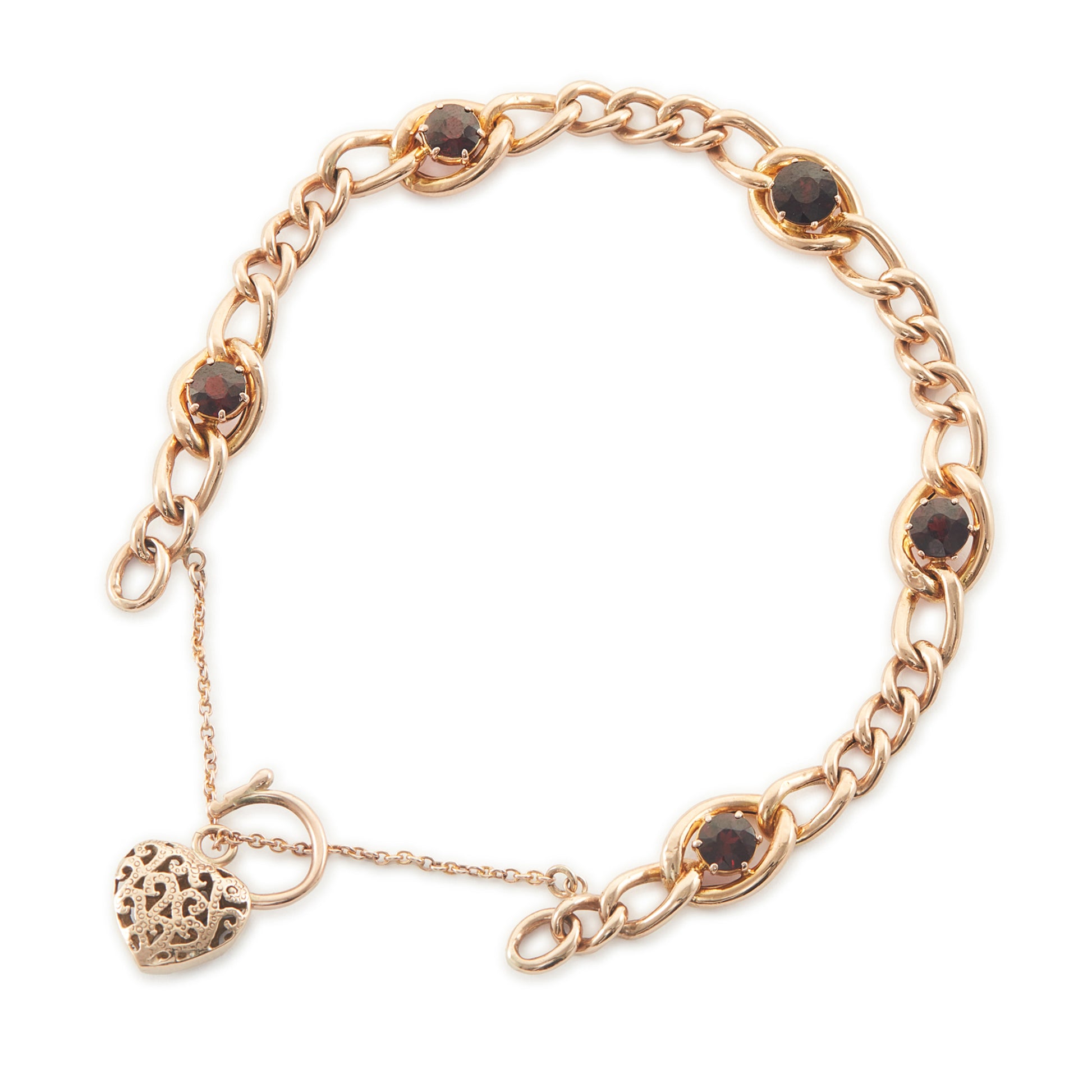 Classic Victorian 9ct rose gold curb link bracelet set with five deep red garnets, finished with an ornate heart padlock. Safety chain attached.
