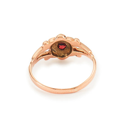 Dainty Victorian 9ct rose gold ring with six seed pearls and a centre garnet in a flower setting.