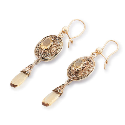 Gorgeous Victorian silver-gilt earrings, each set with a beautifully faceted citrine and a dangling citrine drop. The earrings feature beautiful scroll work detail on the metal.