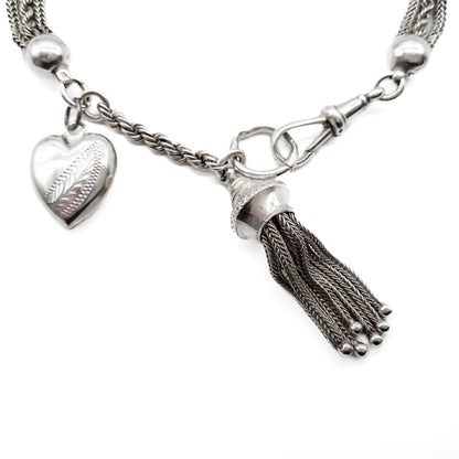 Victorian silver albertina bracelet with ornate detail, a dog clip, a tassel and a heart charm. 