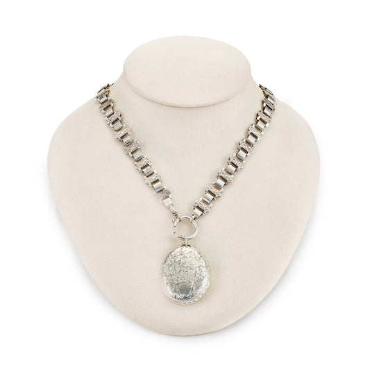 Classic Victorian silver locket on choker with ornate floral engraving.