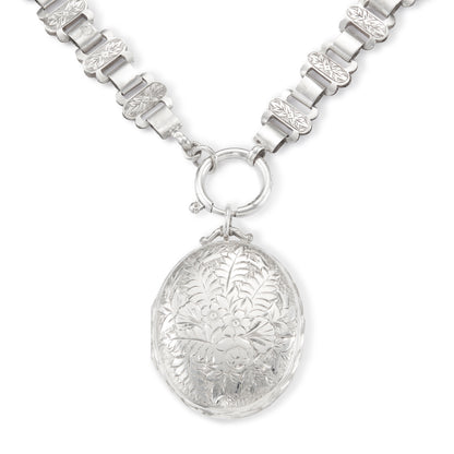 Classic Victorian silver locket on choker with ornate floral engraving.