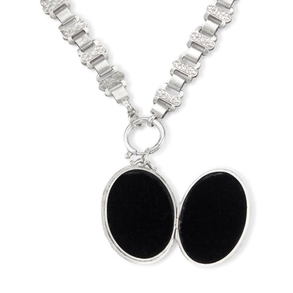 Classic Victorian silver locket on choker with ornate floral engraving.