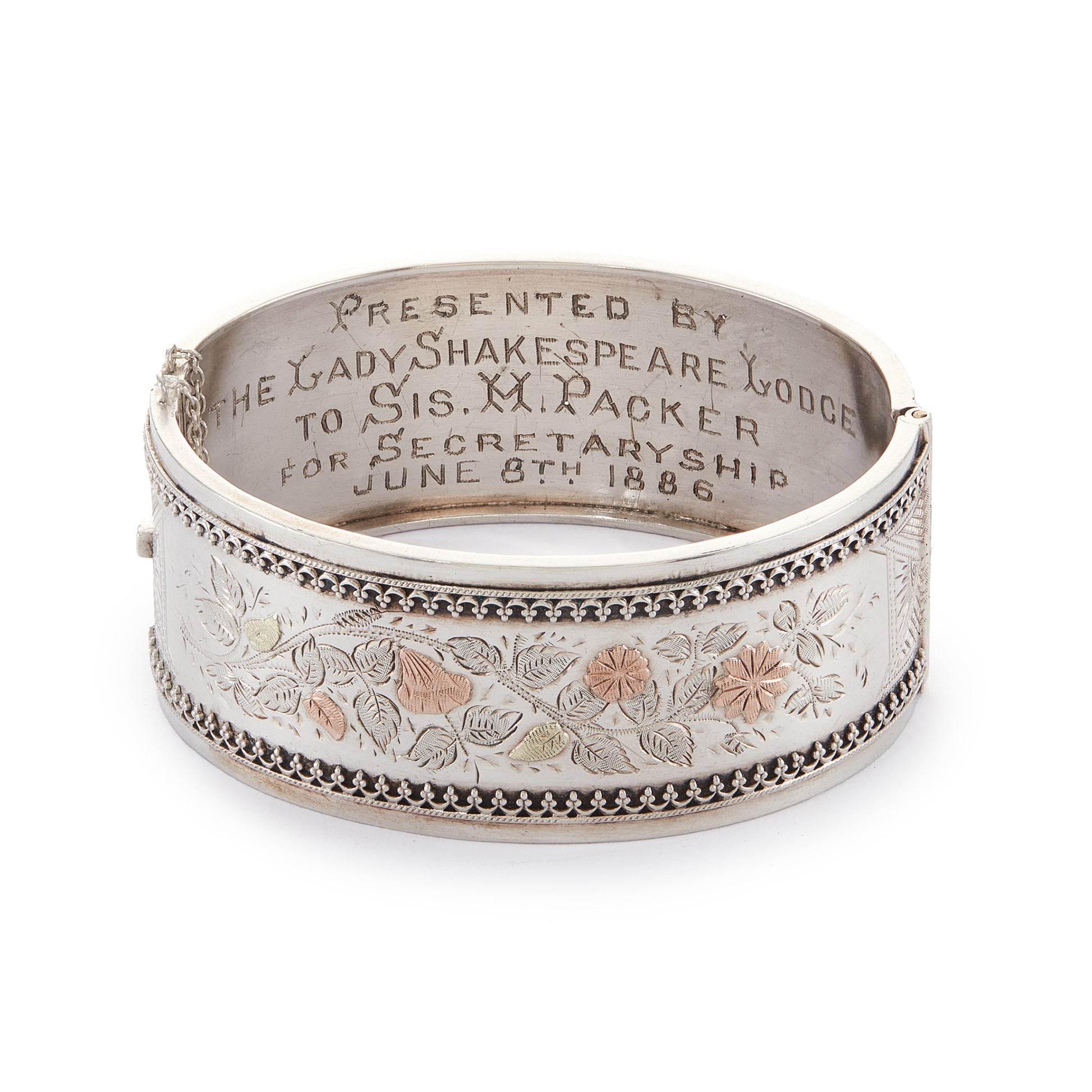 Beautiful Victorian silver and gold bangle embossed with a floral design and Etruscan detail around the rim. Safety chain attached.