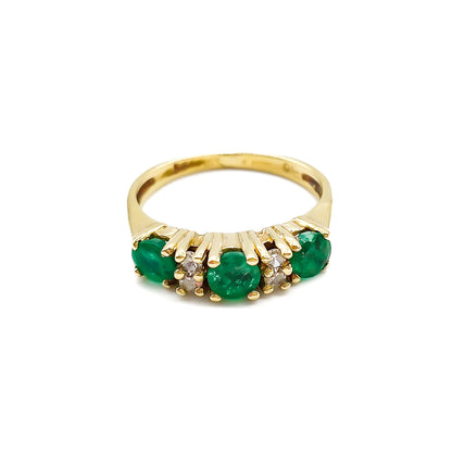 Classic vintage 14ct yellow gold ring set with three round emeralds and four small diamonds.