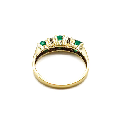 Classic vintage 14ct yellow gold ring set with three round emeralds and four small diamonds.