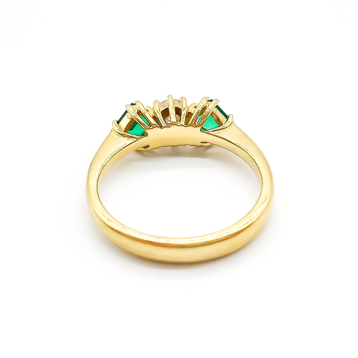 Stunning 18ct yellow gold ring set with a round 0,20ct centre diamond and two bright green princess-cut emeralds.