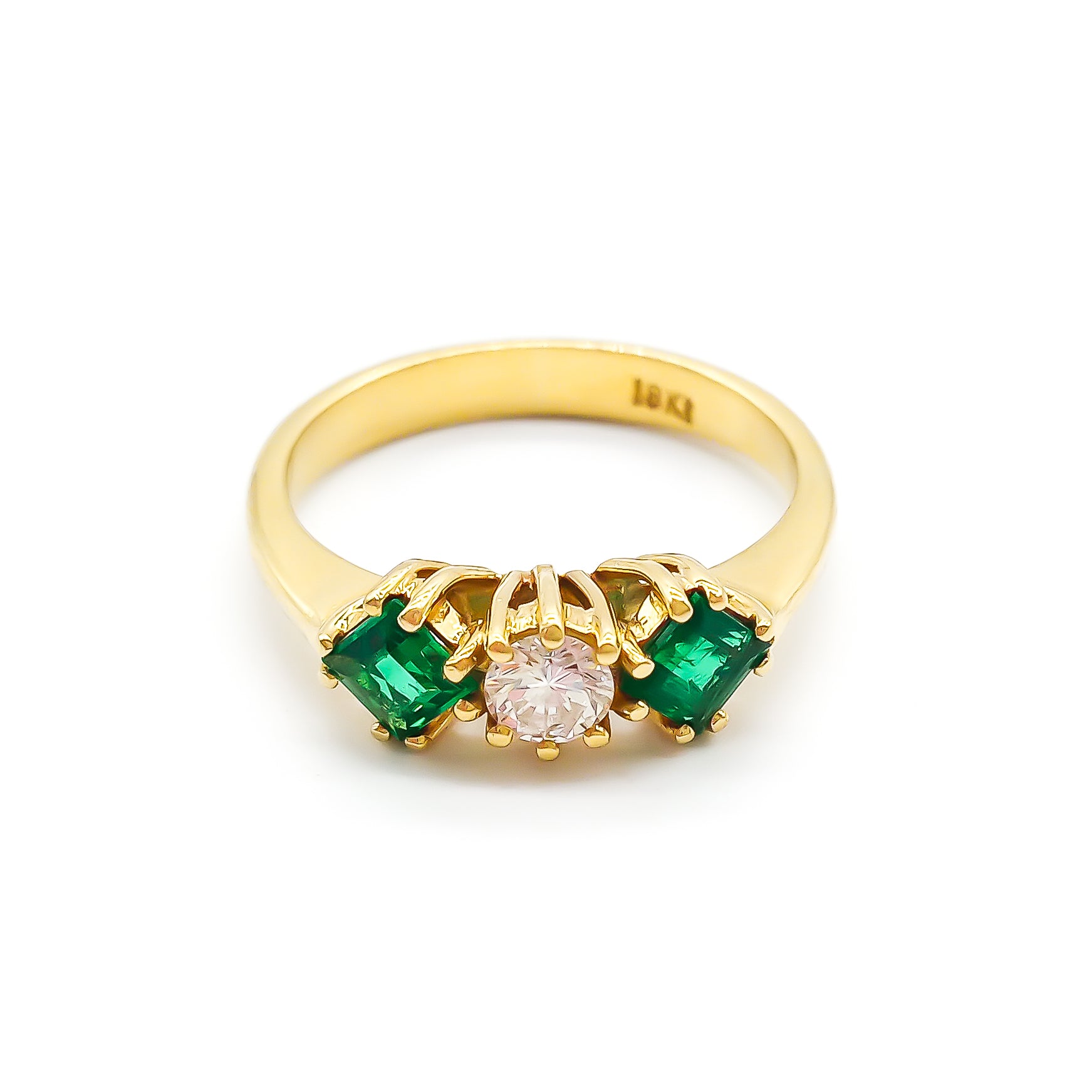 Stunning 18ct yellow gold ring set with a round 0,20ct centre diamond and two bright green princess-cut emeralds.