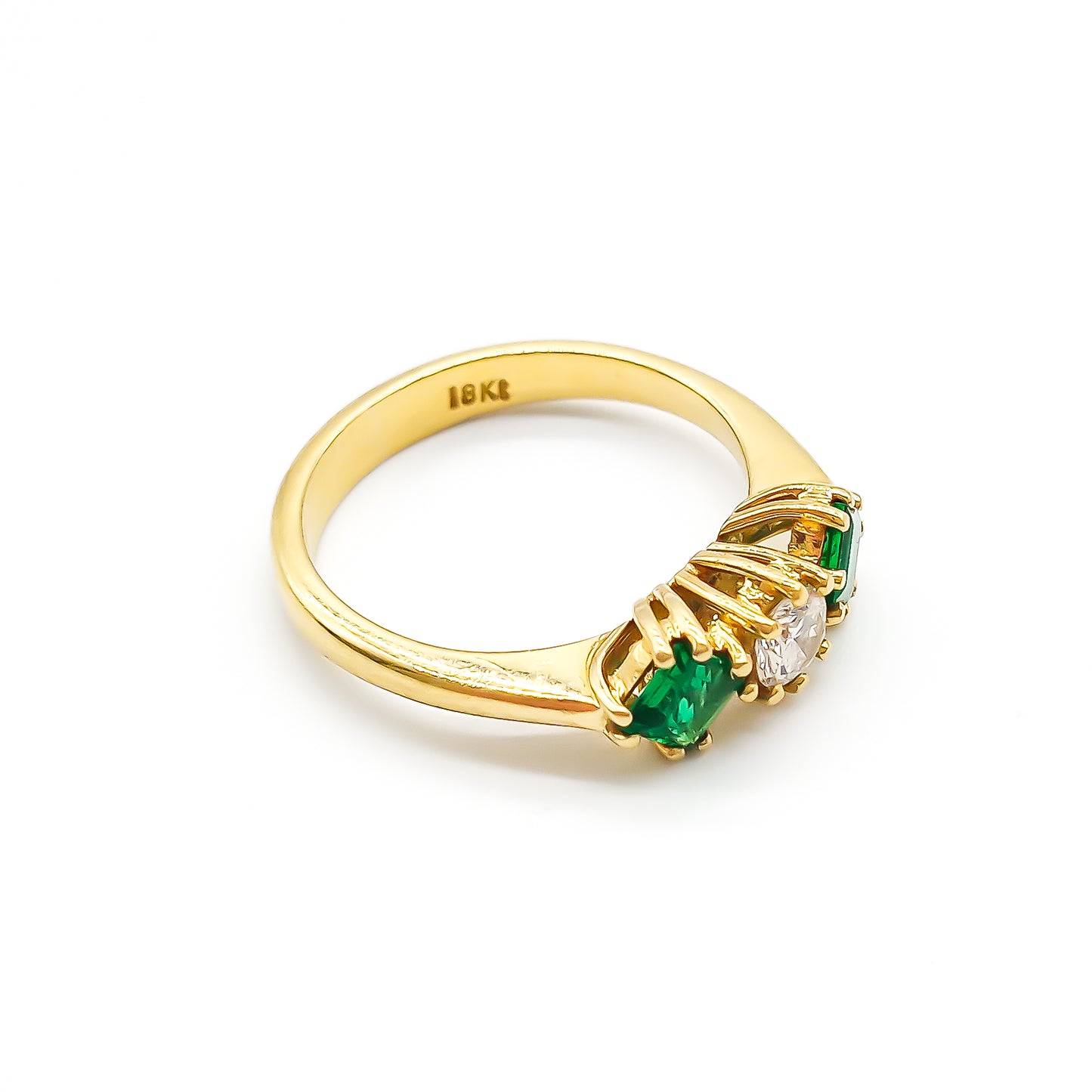 Stunning 18ct yellow gold ring set with a round 0,20ct centre diamond and two bright green princess-cut emeralds.