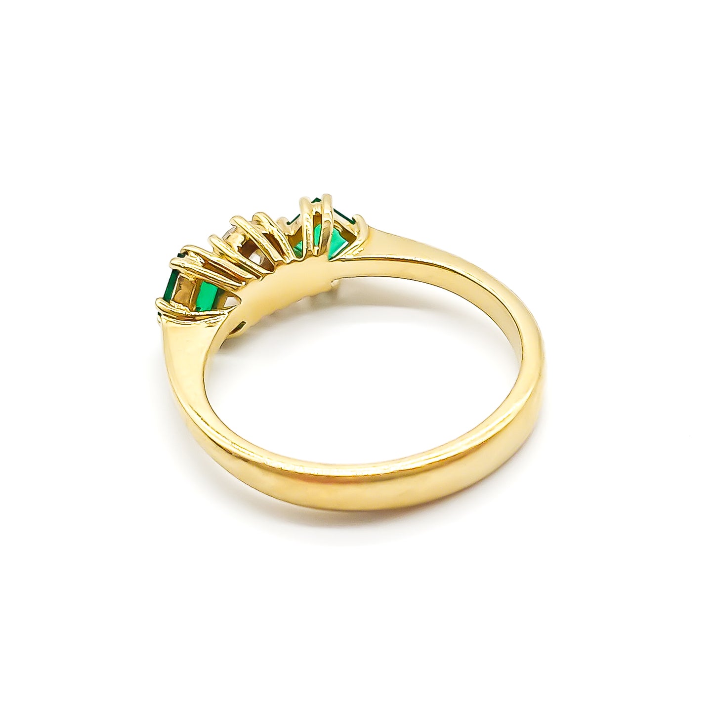 Stunning 18ct yellow gold ring set with a round 0,20ct centre diamond and two bright green princess-cut emeralds.