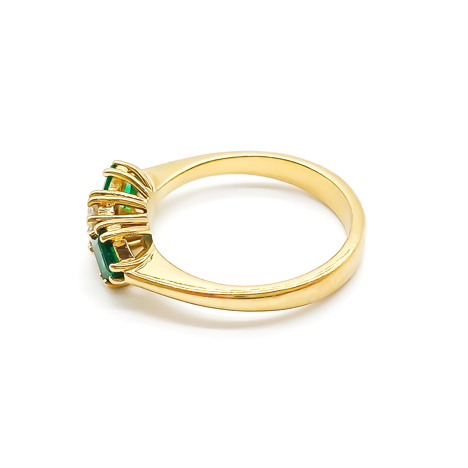 Stunning 18ct yellow gold ring set with a round 0,20ct centre diamond and two bright green princess-cut emeralds.