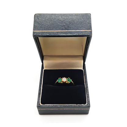 Stunning 18ct yellow gold ring set with a round 0,20ct centre diamond and two bright green princess-cut emeralds.