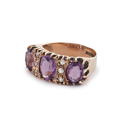 9ct Rose gold trilogy ring set with three beautifully faceted purple amethysts, interspersed with small, white, round-cut spinels.