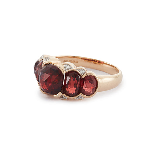 Stunning vintage 9ct gold ring set with five beautifully faceted garnets and eight small diamonds around the stones.