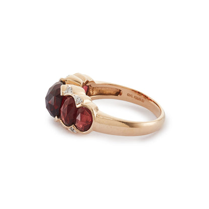 Stunning vintage 9ct gold ring set with five beautifully faceted garnets and eight small diamonds around the stones.