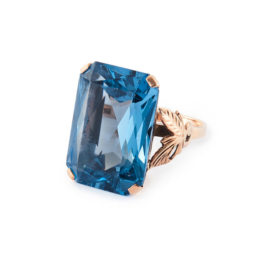 Beautifully faceted deep-blue lab-grown spinel in a lovely 9ct rose gold ring setting with a leaf design.