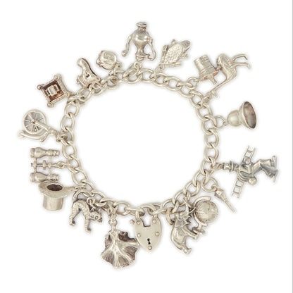 Chunky vintage sterling silver curb link bracelet with seventeen whimsical charms and a heavy padlock. The bracelet has a nice weight to it. 
