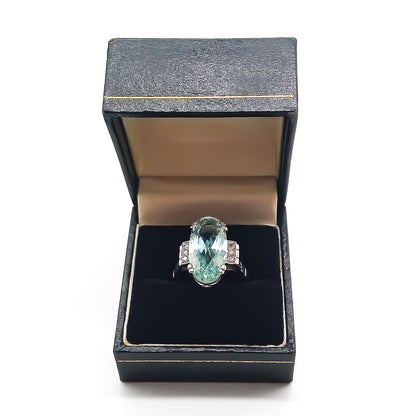 Magnificent 18ct white gold ring set with a beautifully faceted 7ct oval aquamarine and six small diamonds.